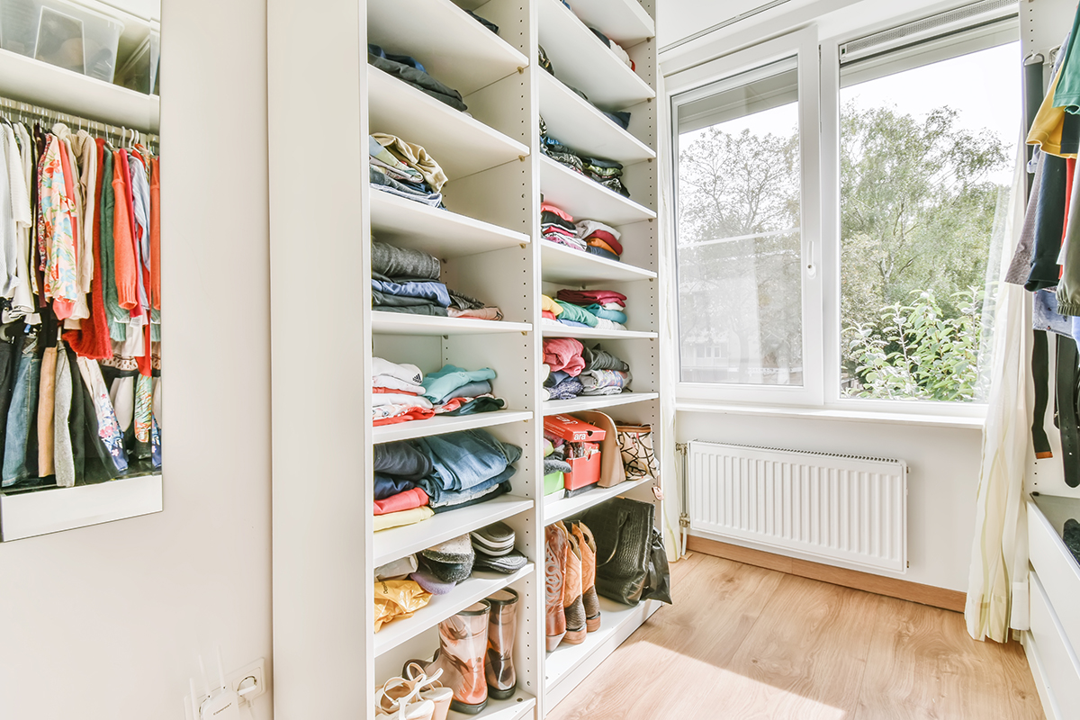 Small dressing room with many shelves in white tones