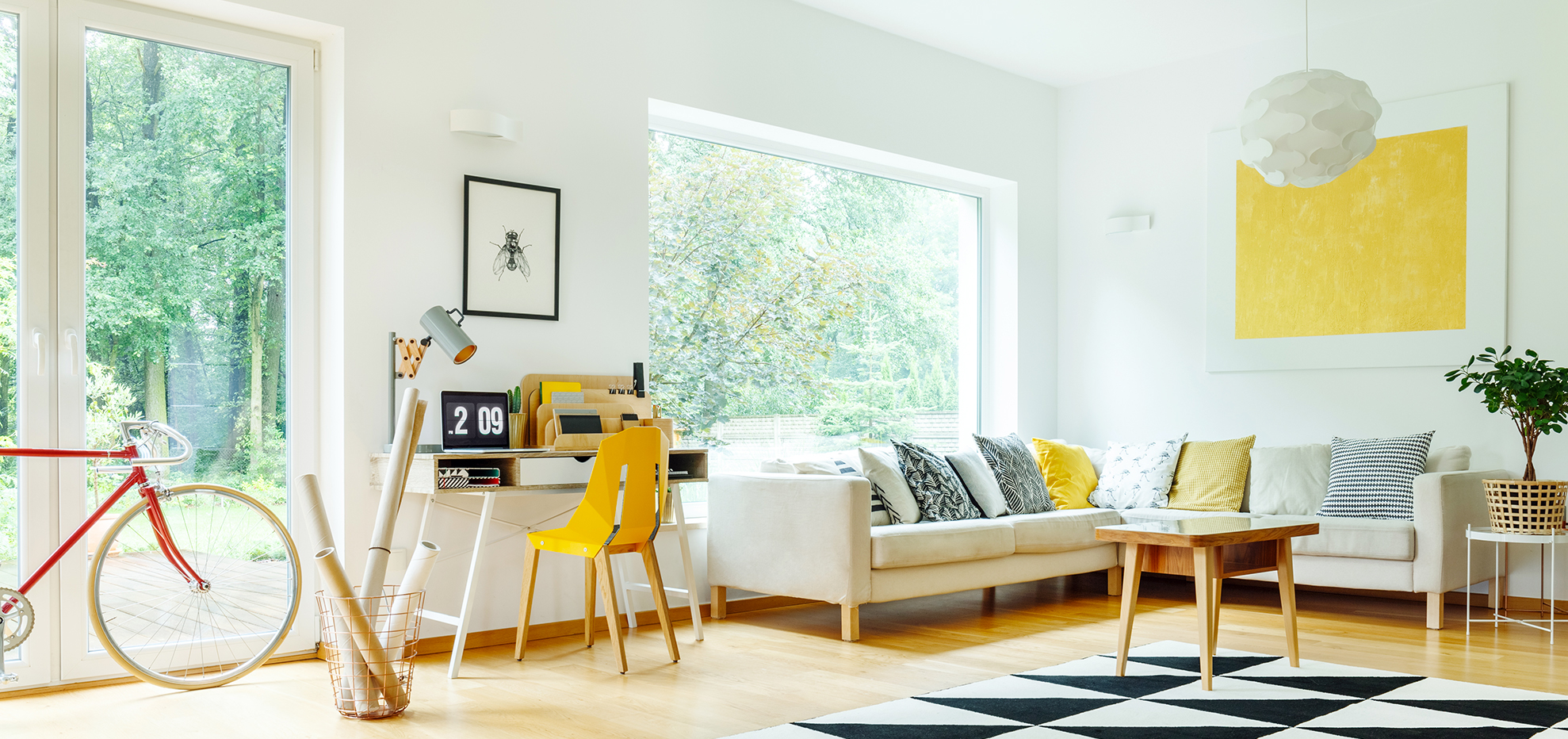 Black and white geometric carpet in spacious living room with yellow painting above corner couch